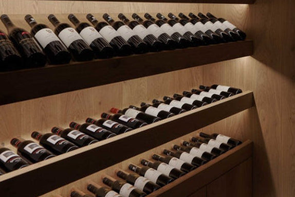 Wooden wine rack with bottles in a dimly lit room
